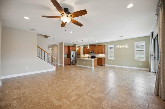 unfurnished living room featuring ceiling fan, sink, and light tile patterned floors