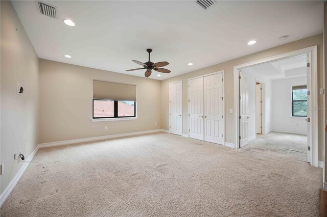 spare room featuring light carpet and ceiling fan