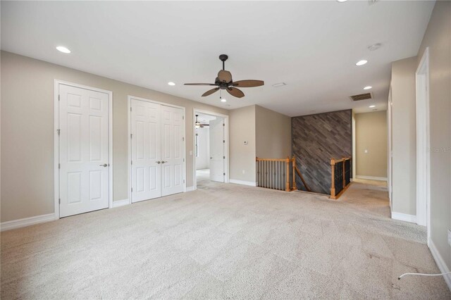 unfurnished living room featuring ceiling fan and light colored carpet