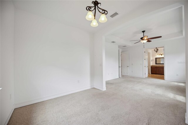 unfurnished living room with ceiling fan with notable chandelier and carpet flooring