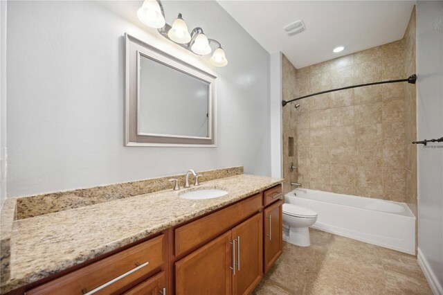 full bathroom featuring tile patterned floors, vanity, tiled shower / bath, and toilet