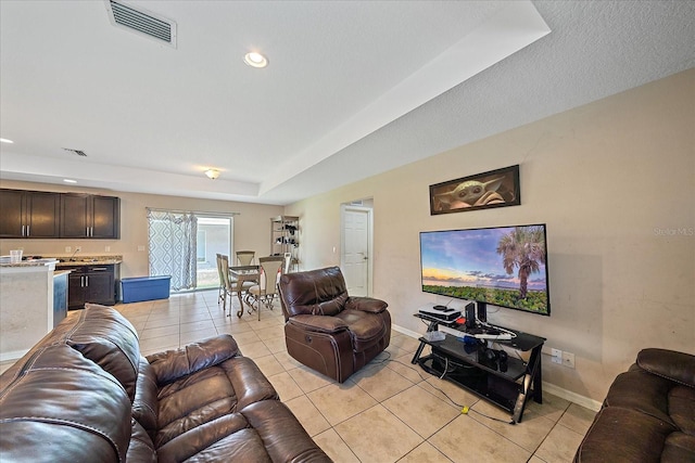 tiled living room featuring a raised ceiling