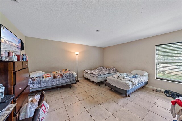 tiled bedroom with a textured ceiling