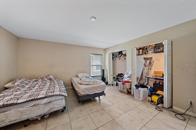 bedroom with light tile patterned floors and a textured ceiling