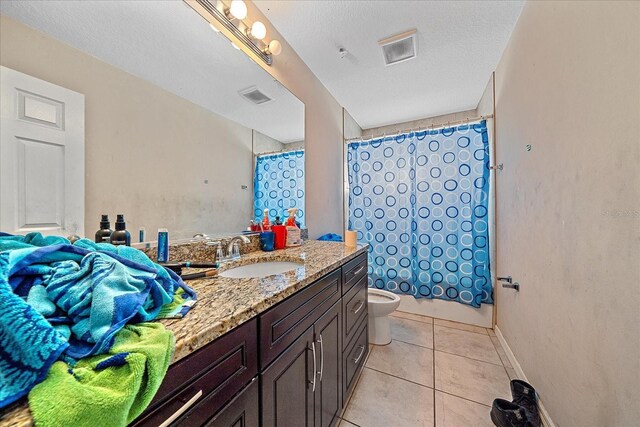 bathroom featuring toilet, a textured ceiling, tile patterned floors, and vanity