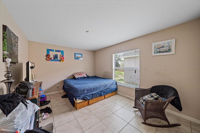 bedroom with a textured ceiling and light tile patterned flooring