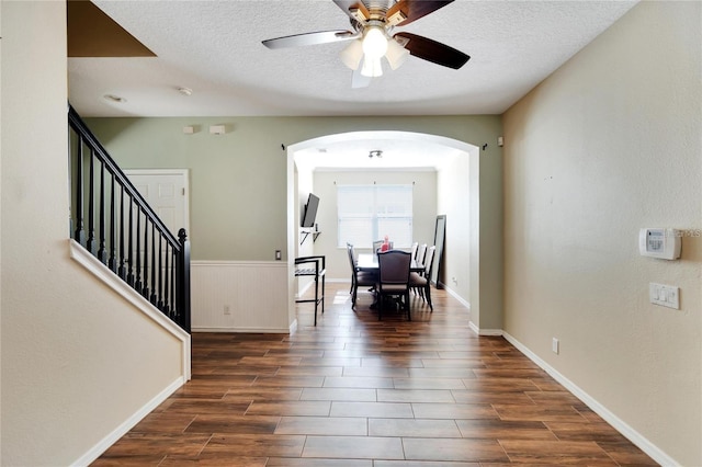 foyer featuring ceiling fan, a textured ceiling, and dark wood-type flooring