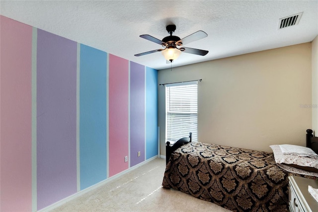 carpeted bedroom featuring a textured ceiling and ceiling fan