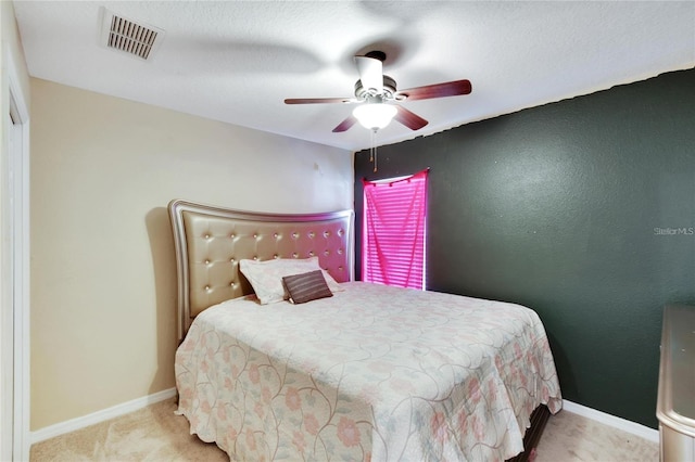 carpeted bedroom with ceiling fan and a textured ceiling