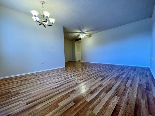 unfurnished room with ceiling fan with notable chandelier and hardwood / wood-style floors