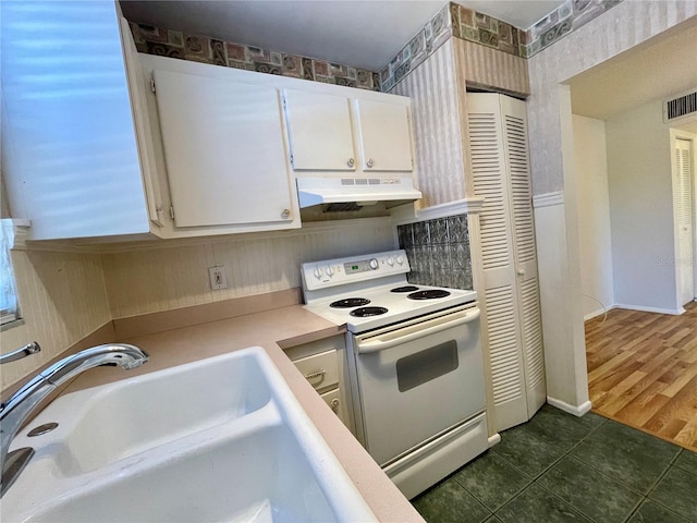 kitchen with sink, white electric range oven, white cabinets, and dark tile patterned flooring