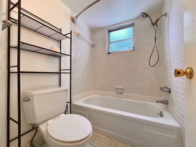 bathroom featuring tiled shower / bath combo, tile patterned flooring, and toilet