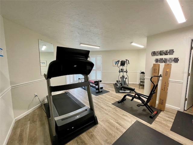 workout room with hardwood / wood-style floors and a textured ceiling