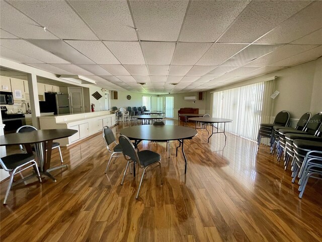 dining area with a paneled ceiling and hardwood / wood-style flooring