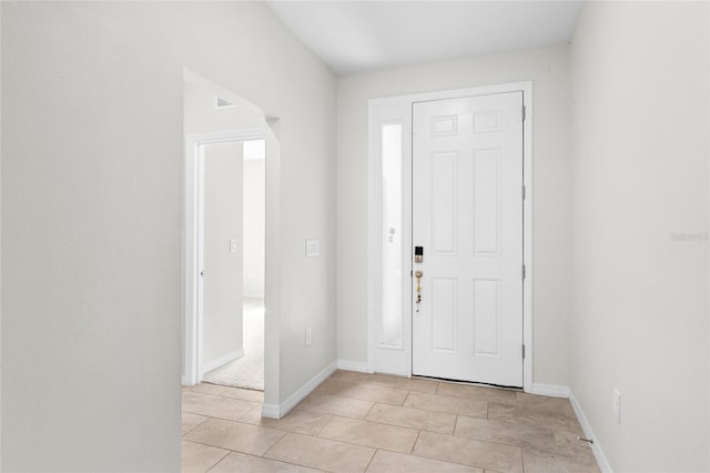 foyer with baseboards and light tile patterned flooring