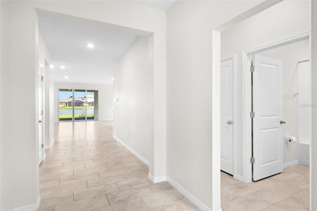 hall featuring recessed lighting and baseboards