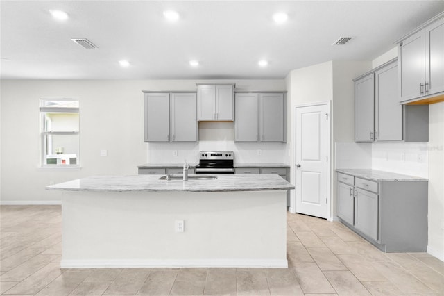 kitchen with gray cabinetry, a kitchen island with sink, visible vents, and stainless steel range with electric cooktop