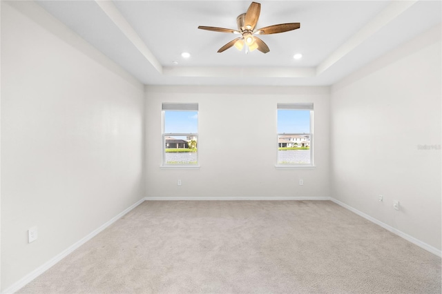 empty room featuring recessed lighting, a raised ceiling, ceiling fan, and baseboards