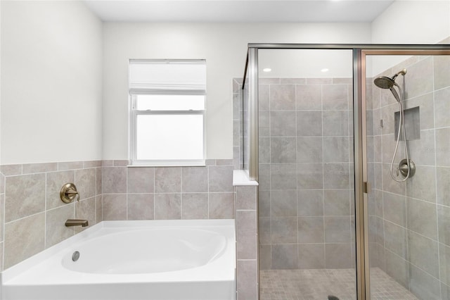 bathroom with a shower stall and a bath