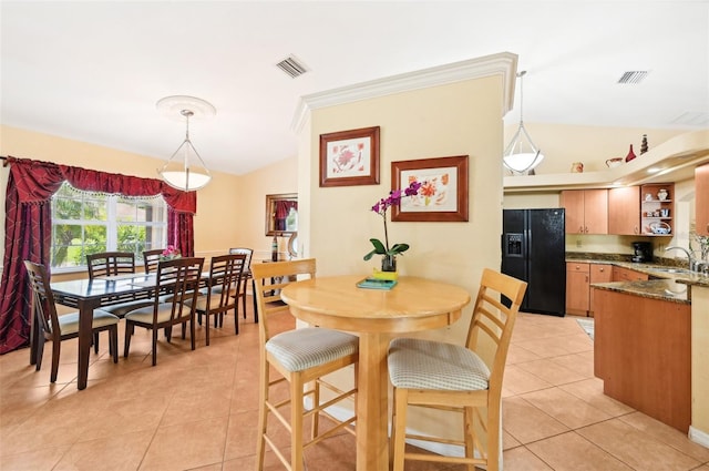 dining area with vaulted ceiling and light tile patterned floors