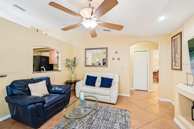 living room with light tile patterned floors, sink, and ceiling fan