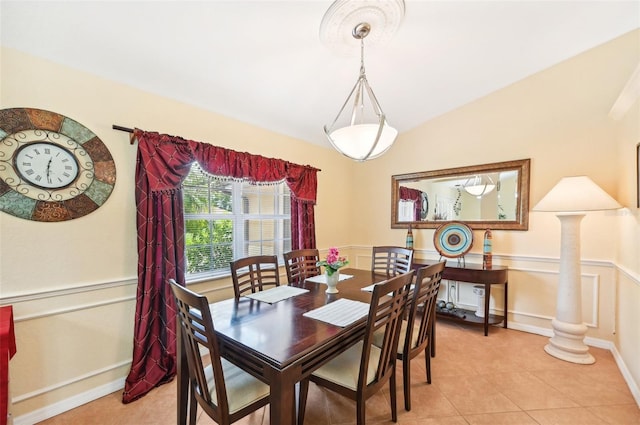 dining space with ornate columns, light tile patterned floors, and vaulted ceiling