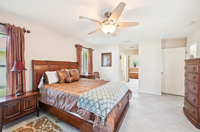 tiled bedroom with connected bathroom and ceiling fan