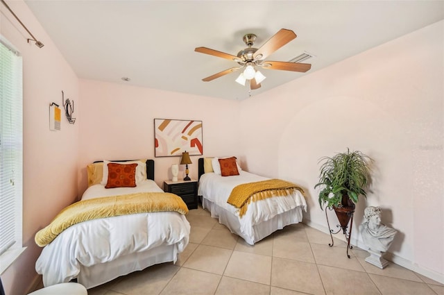 bedroom with ceiling fan and light tile patterned floors