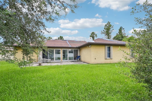 back of house featuring a patio area and a lawn