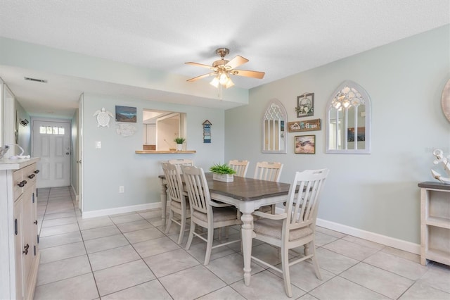 dining space featuring light tile patterned floors, a textured ceiling, and ceiling fan