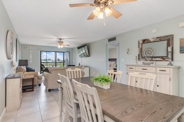 tiled dining room featuring ceiling fan and a textured ceiling