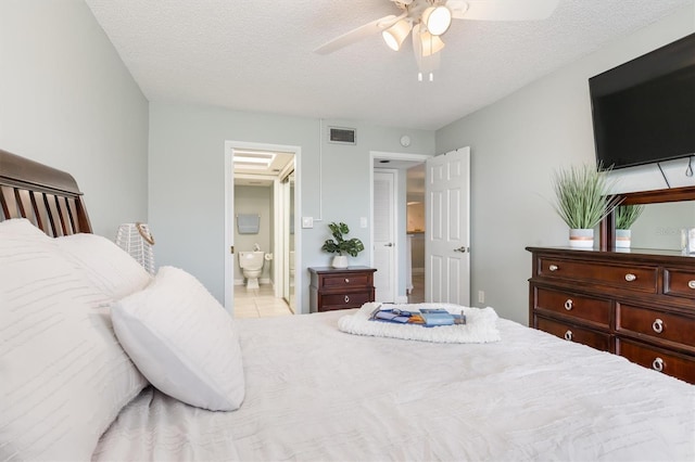 bedroom featuring light tile patterned floors, ensuite bathroom, a textured ceiling, and ceiling fan