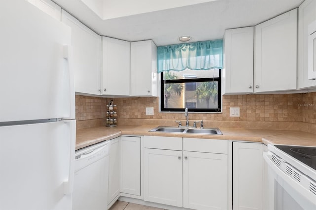 kitchen with backsplash, white appliances, sink, and white cabinets