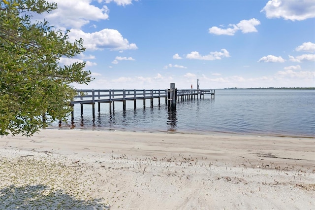 dock area with a water view and a beach view