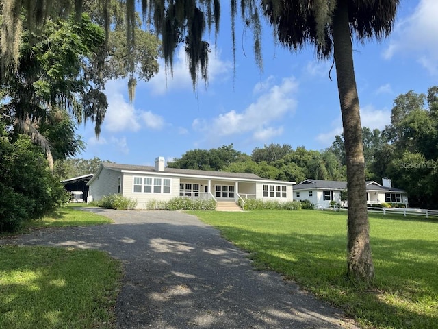 ranch-style home featuring a front yard and a carport