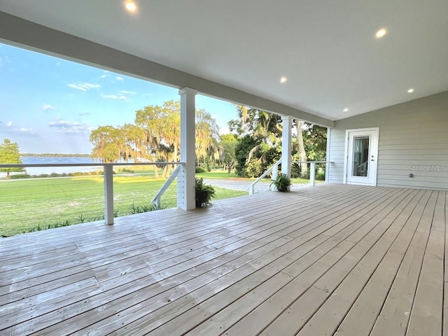 wooden deck with a lawn and a water view