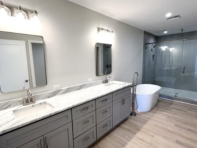 bathroom featuring hardwood / wood-style floors, vanity, and independent shower and bath