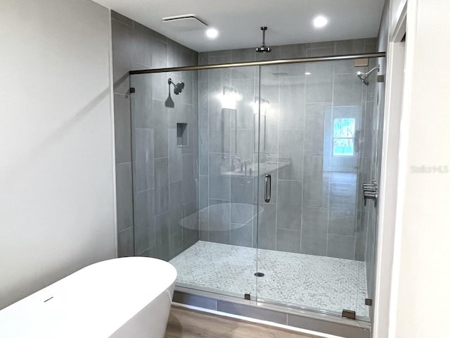 bathroom featuring hardwood / wood-style floors and independent shower and bath