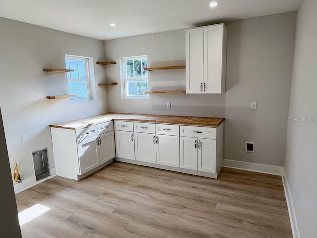 kitchen featuring white cabinets, wooden counters, and light wood-type flooring