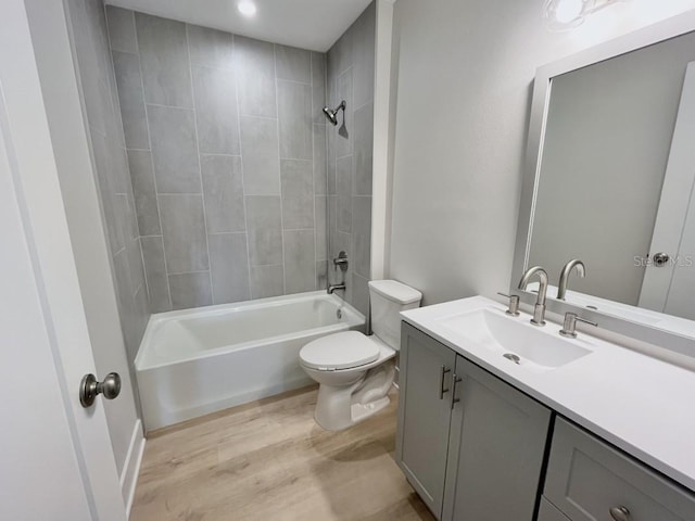 full bathroom with toilet, vanity, tiled shower / bath combo, and hardwood / wood-style flooring