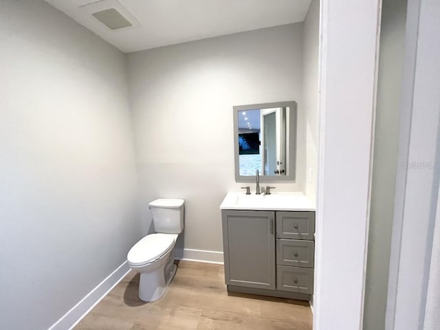 bathroom with vanity, toilet, and wood-type flooring