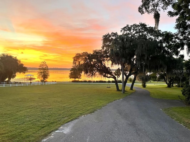 view of home's community with a lawn and a water view