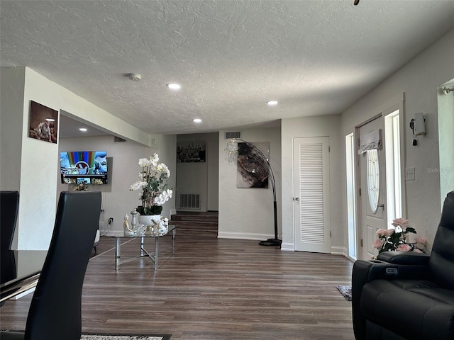 living room with a textured ceiling and wood-type flooring