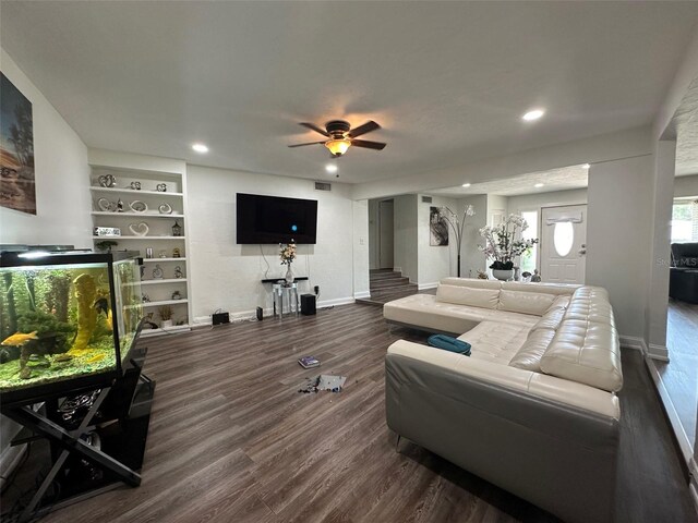 living room with dark hardwood / wood-style flooring and ceiling fan