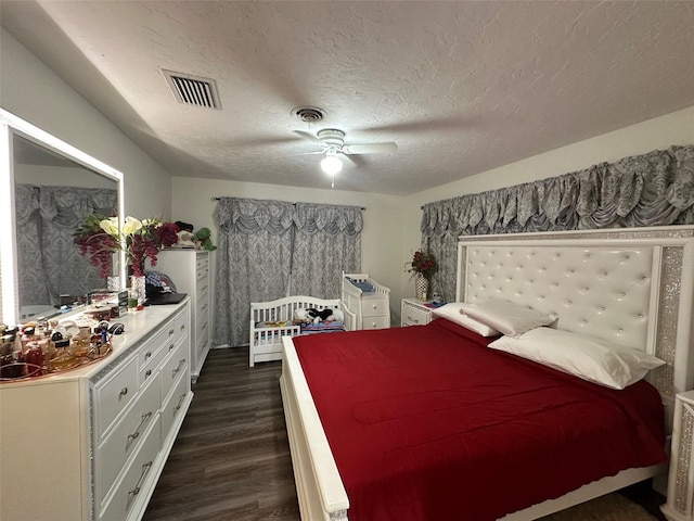 bedroom featuring a textured ceiling, ceiling fan, and dark hardwood / wood-style flooring