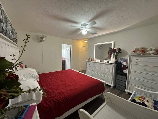 bedroom featuring ceiling fan, dark wood-type flooring, a textured ceiling, and a closet