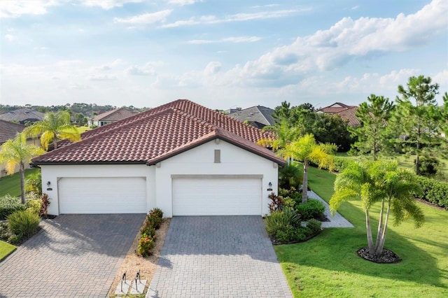 mediterranean / spanish-style house with a garage and a front lawn