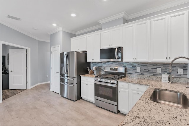 kitchen featuring sink, stainless steel appliances, white cabinets, and light stone countertops