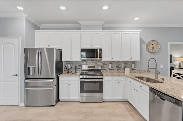 kitchen featuring sink, decorative backsplash, light stone countertops, white cabinetry, and stainless steel appliances