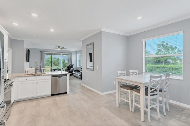 kitchen with sink, white cabinetry, appliances with stainless steel finishes, ceiling fan, and crown molding